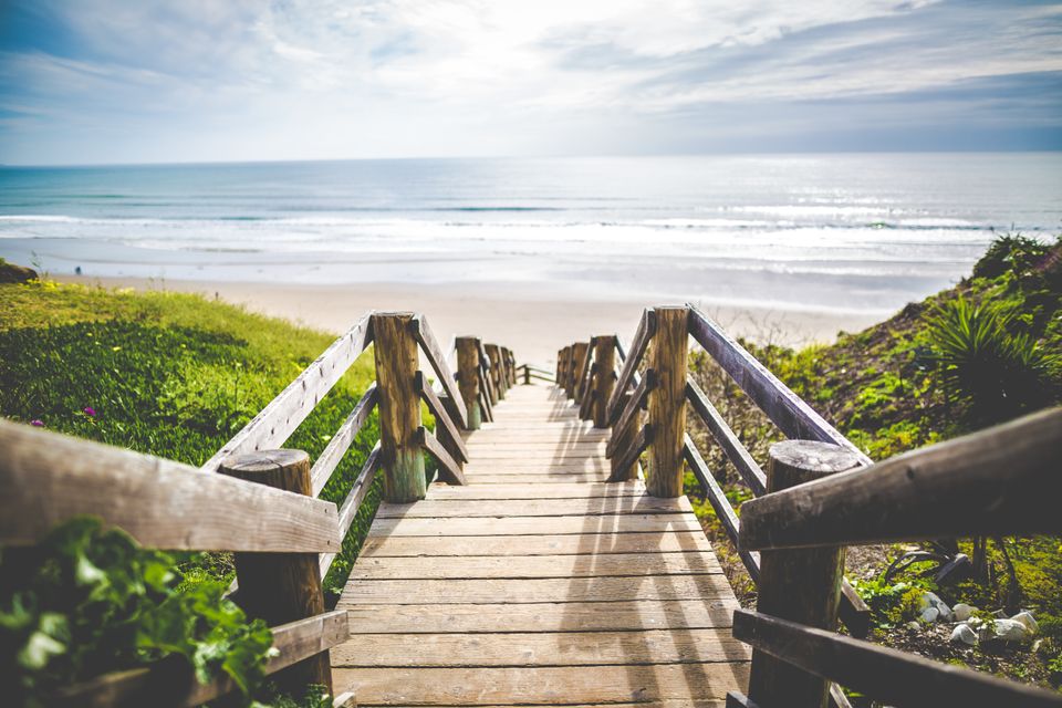 The image is of wooden stairs leading down to beach.
